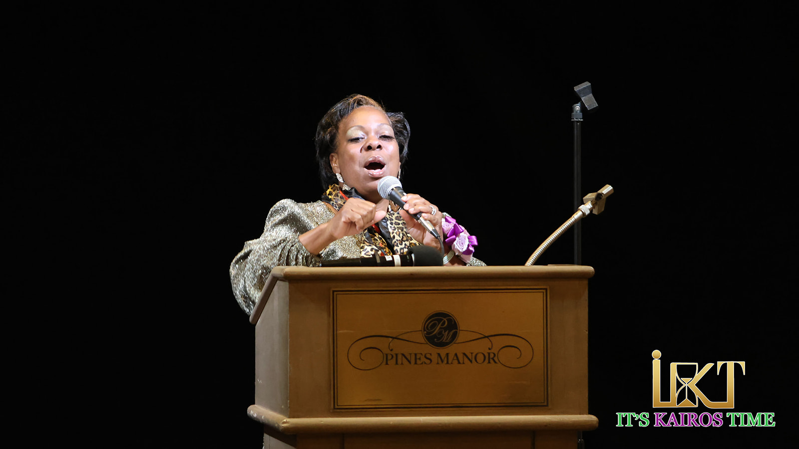 Speaker at Pines Manor podium with microphone