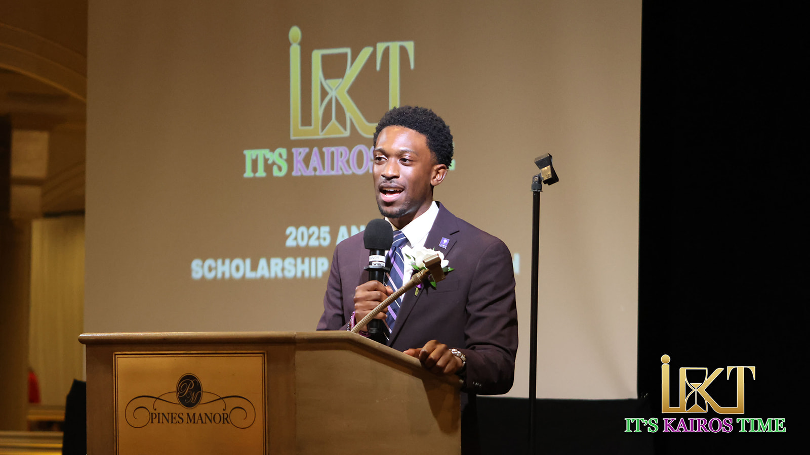 Man speaking at podium with event logo