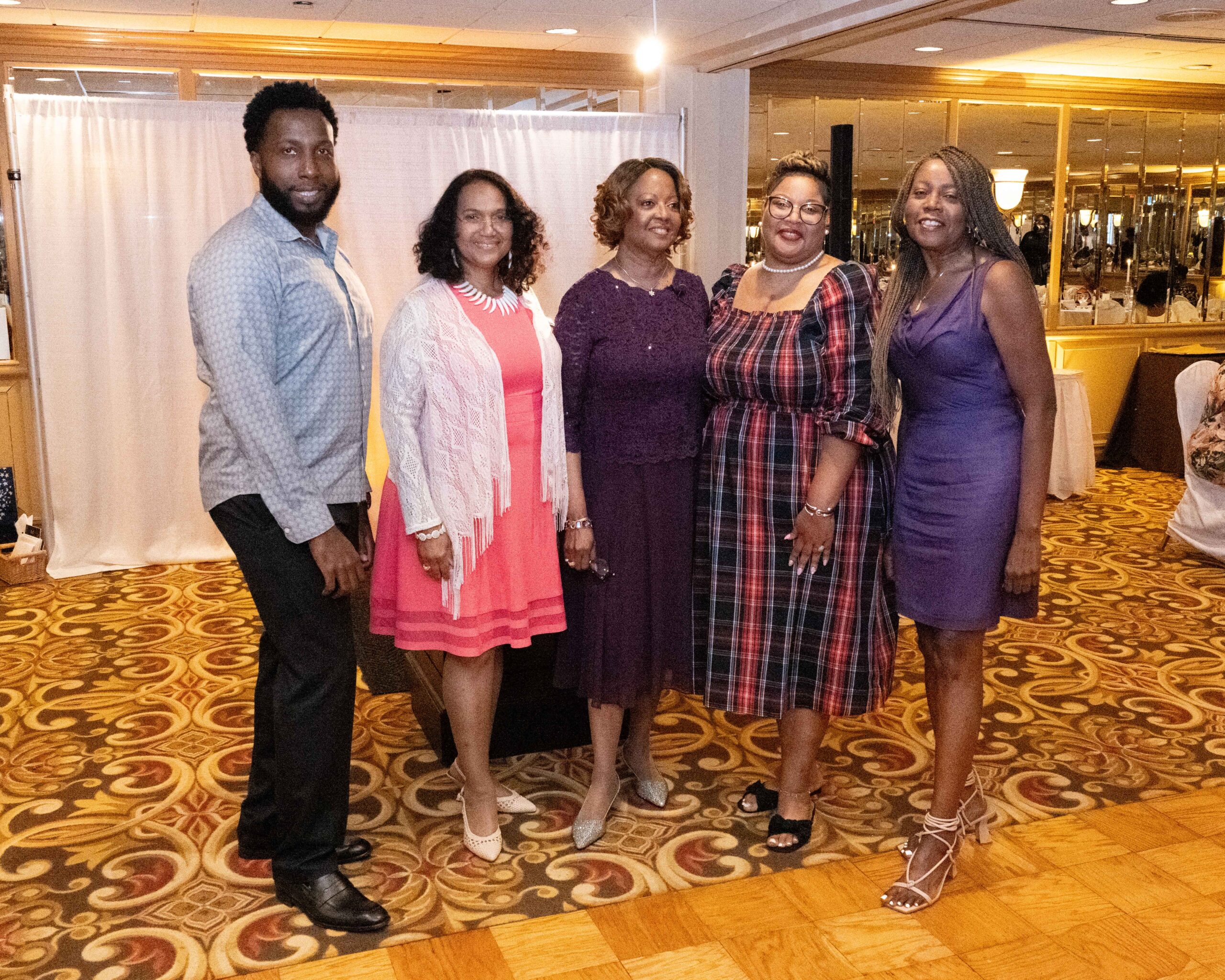 Group of five people dressed elegantly at an indoor event.